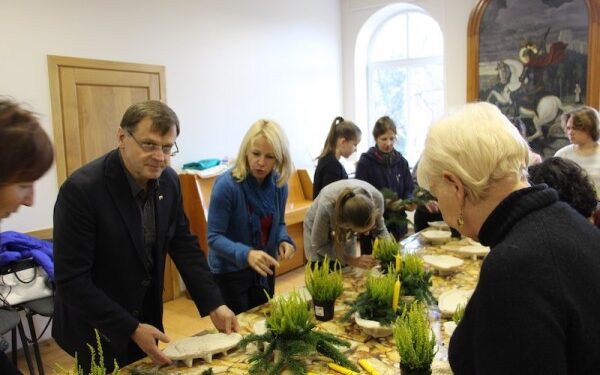 Bendruomenės nariai ruošia puokšteles ir žvakes kapų papuošimui
